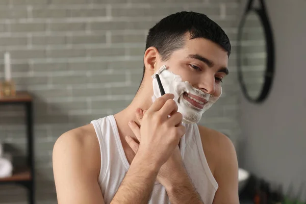 在浴室刮胡子的年轻人 — 图库照片