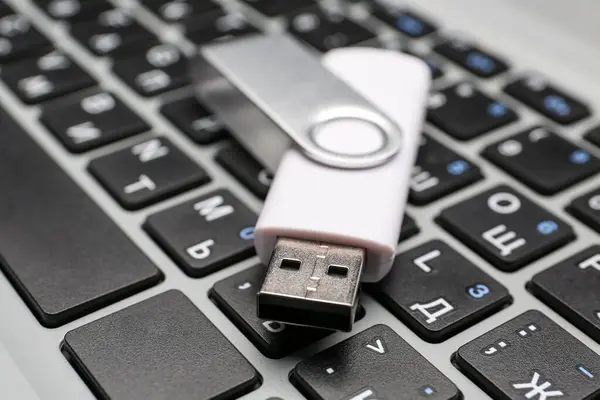 stock image White USB flash drive on modern laptop, closeup