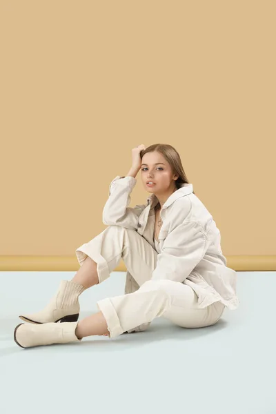Mujer Joven Moda Ropa Elegante Sentada Cerca Pared Beige —  Fotos de Stock