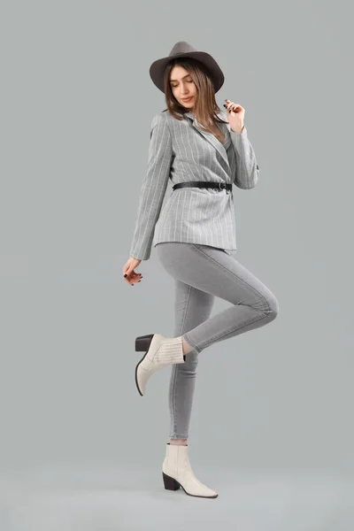 Stilvolle Junge Frau Jacke Jeans Und Hut Auf Grauem Hintergrund — Stockfoto