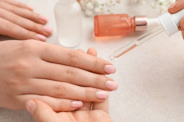 Manicure Master Aanbrengen Van Nagelriemolie Vrouwelijke Nagels Lichte Achtergrond Close — Stockfoto