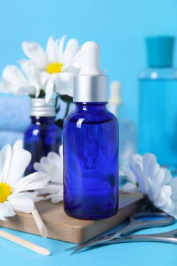 Renkli arkaplanda manikür aletleri ve papatya çiçeği şişeleri ile kompozisyon, yakın plan