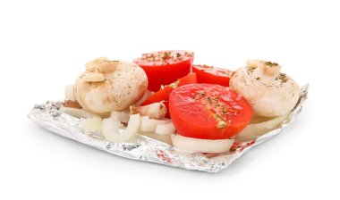 Beyaz arka planda çiğ sebzeli alüminyum folyo