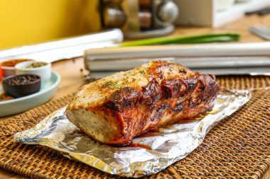 Mutfaktaki masada lezzetli pişmiş etle alüminyum folyo, yakın plan.