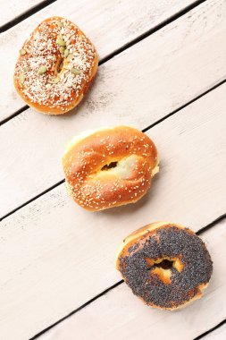 Hafif ahşap arka planda susamlı ve haşhaş tohumlu lezzetli simit.