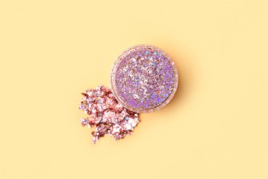 Sarı arkaplandaki parıltılı kavanoz, yakın plan.