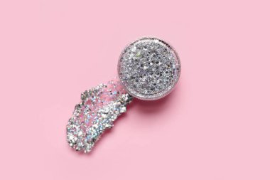 Pembe arka planda bir kavanoz gümüş parıltı, yakın plan