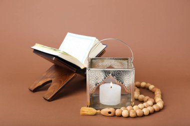 Kahverengi zemin üzerinde tespih ve Kur 'an olan Müslüman lambası