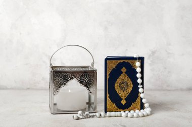 Müslüman lambası yanan mum, Kur 'an ve arkaplanda dua boncukları