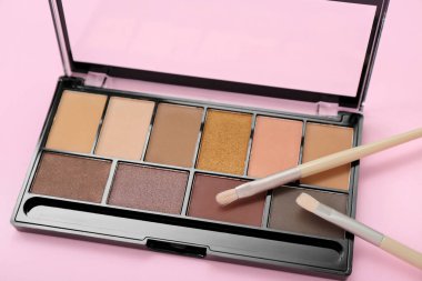 Pembe arka planda fırçalı göz falı paleti, yakın plan.