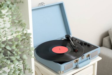 Oturma odasındaki rafta vinil diski olan kayıt çalar