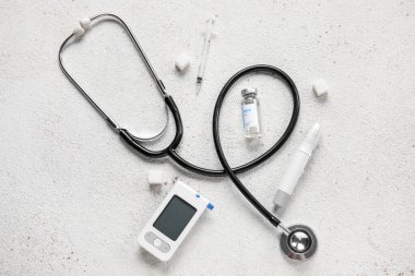 İnsülin, tükenmez kalem, steteskop ve beyaz arka planda şeker içeren glukometre. Diyabet kavramı