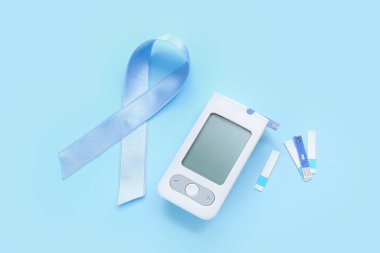 Mavi arka planda glukometre ve şeritli farkındalık şeridi. Diyabet kavramı