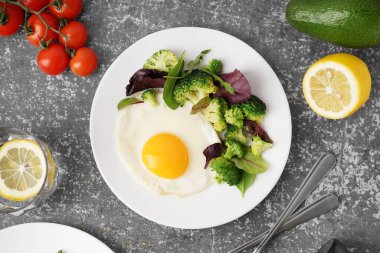 Lezzetli kızarmış yumurta, brokoli ve grunge arka planda ıspanak.