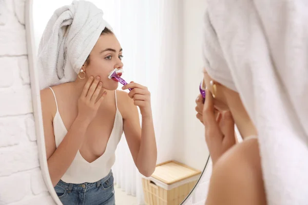 Mujer Joven Afeitándose Cara Con Afeitadora Cerca Del Espejo Baño — Foto de Stock