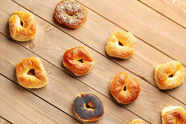 stock image Tasty bagels with sesame and poppy seeds on wooden background