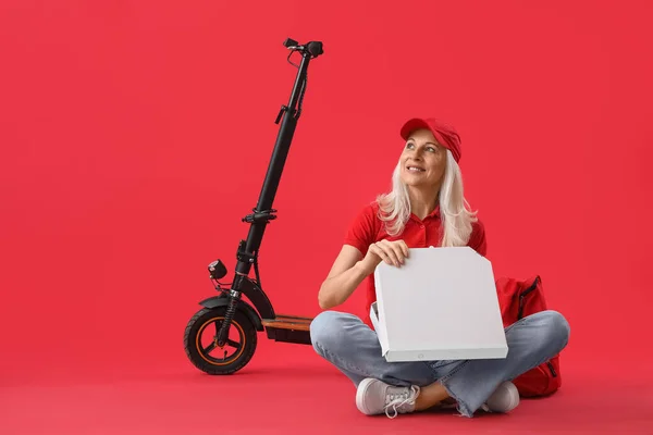 Kırmızı Arka Planda Pizza Elektrikli Bisikleti Olan Olgun Kurye — Stok fotoğraf