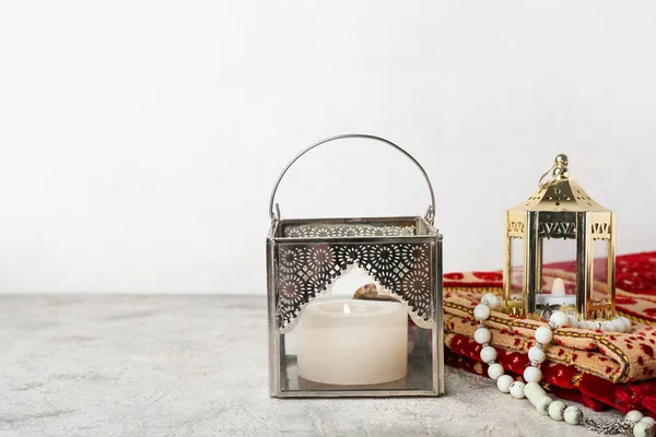 白墙附近桌上放有蜡烛 祈祷珠子和垫子的穆斯林灯 — 图库照片