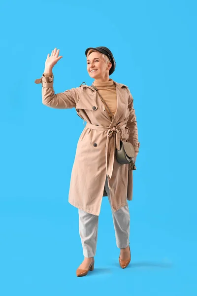 Κομψή Ώριμη Γυναίκα Κουνώντας Χέρι Γαλάζιο Φόντο — Φωτογραφία Αρχείου