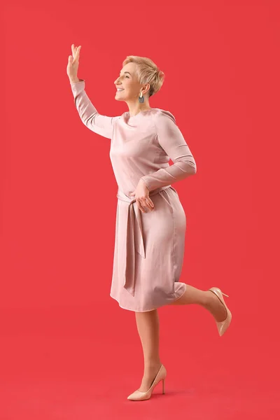 Stylish Mature Woman Waving Hand Red Background — Stock Photo, Image