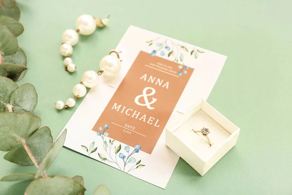 有订婚戒指 婚宴邀请函和绿色背景桉树枝条的盒子 — 图库照片