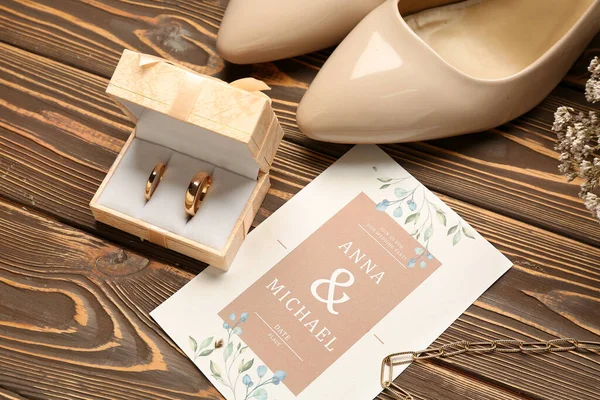 有结婚戒指的盒子 木制背景的邀请函和高跟鞋 — 图库照片