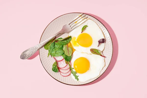 Πιάτο Νόστιμα Τηγανητά Αυγά Ραπανάκι Και Σπανάκι Ροζ Φόντο — Φωτογραφία Αρχείου