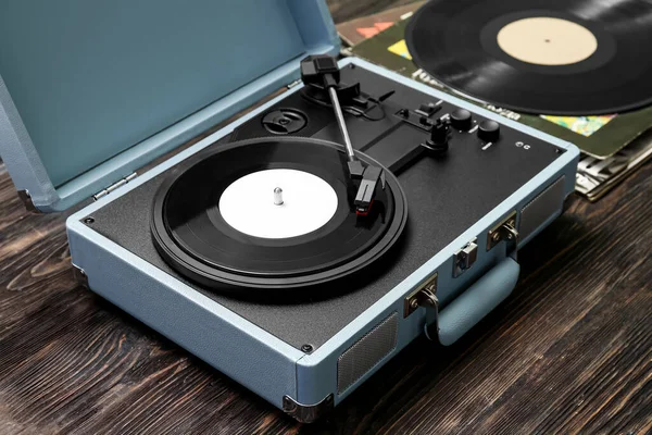 Record player with vinyl disk on dark wooden background, closeup