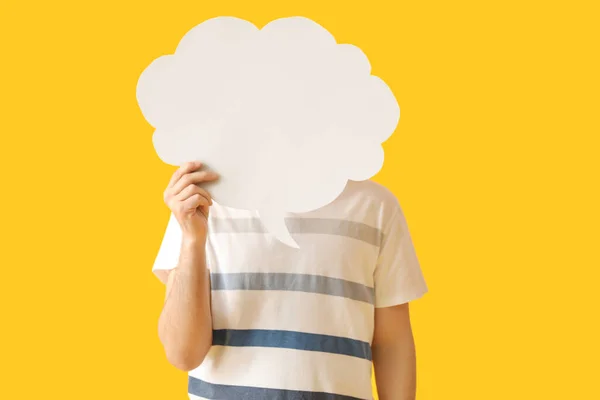 Young man with blank speech bubble on yellow background