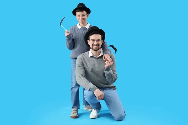 Retrato Pai Seu Filho Com Bigode Papel Fundo Azul Claro — Fotografia de Stock