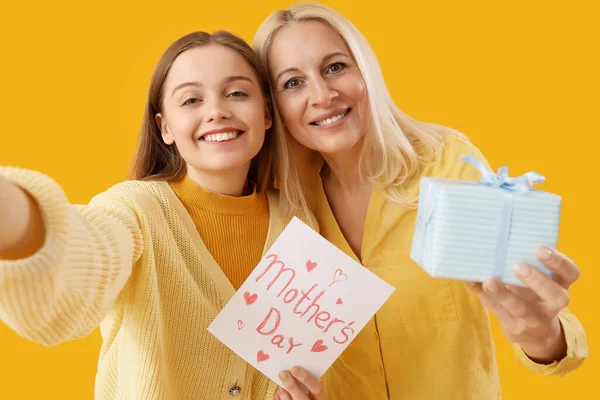 Young Woman Her Mother Gift Taking Selfie Orange Background — Stock Photo, Image