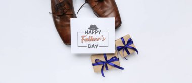 Mutlu Babalar Günü yazılı kart, şık ayakkabılar ve beyaz arka planda hediyeler