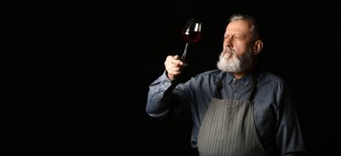 Koyu arkaplandaki olgun şarap garsonunun portresi metin için boşluk