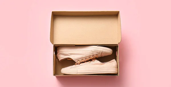 纸板箱 带有粉色背景的时髦休闲鞋 — 图库照片
