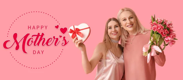快乐的女人和她的女儿 有着粉色背景的花朵和礼物 母亲节庆祝活动 — 图库照片