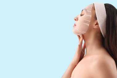 Mavi arka planda çarşaf maskeli genç bayan, yakın plan.