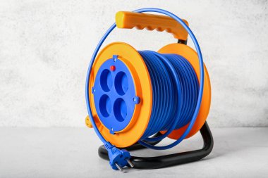 Işık arkaplanındaki uzatmalı elektrik kablo makarası