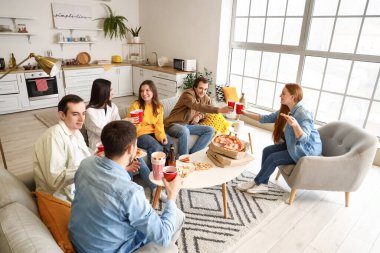 Evde lezzetli pizzaları ve içkileri olan bir grup arkadaş