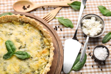 Lezzetli kiş, ıspanak yaprakları ve peçetenin üstündeki çatal bıçaklar, yakın plan.