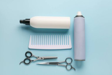 Renkli arka planda saç spreyi, tarak ve makas şişeleriyle kompozisyon