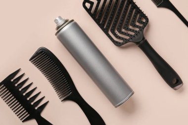 Bir şişe saç spreyi, taraklar ve renk arkaplanı, yakın plan