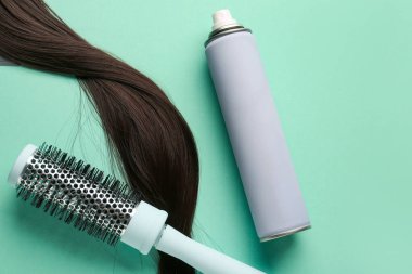 Saç spreyi şişesi, fırça ve renk arkaplanı