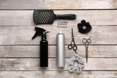 Farklı saç spreyleri, fırça, makas ve saç tokaları.