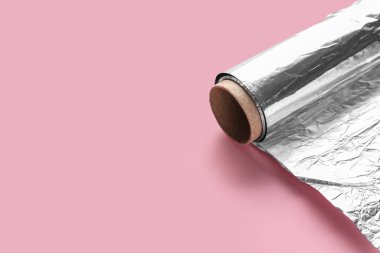 Pembe arkaplanda alüminyum folyo rulo