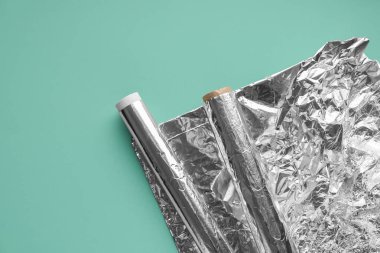 Rolls of aluminium foil on color background