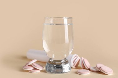 Renk arkaplan üzerinde çözünebilir tablet ve bir bardak su