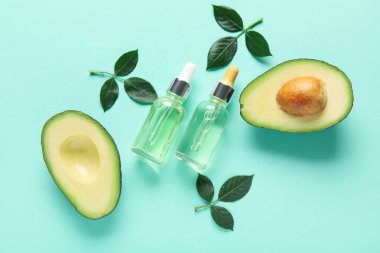 Renk arkaplanında manikür yağı, avokado ve bitki yaprakları olan bileşim