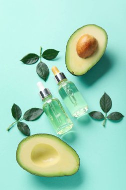 Renk arkaplanında manikür yağı, avokado ve bitki yaprakları olan bileşim
