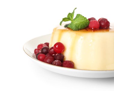 Lezzetli puding, nane ve karamelli yaban mersini tabağı beyaz arka planda izole edilmiş.