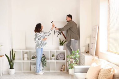 Evdeki ışık duvarında asılı duran genç bir çift.